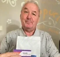 Studienteilnehmer Herr Alfred S. präsentiert den Notizblock von SHARE.