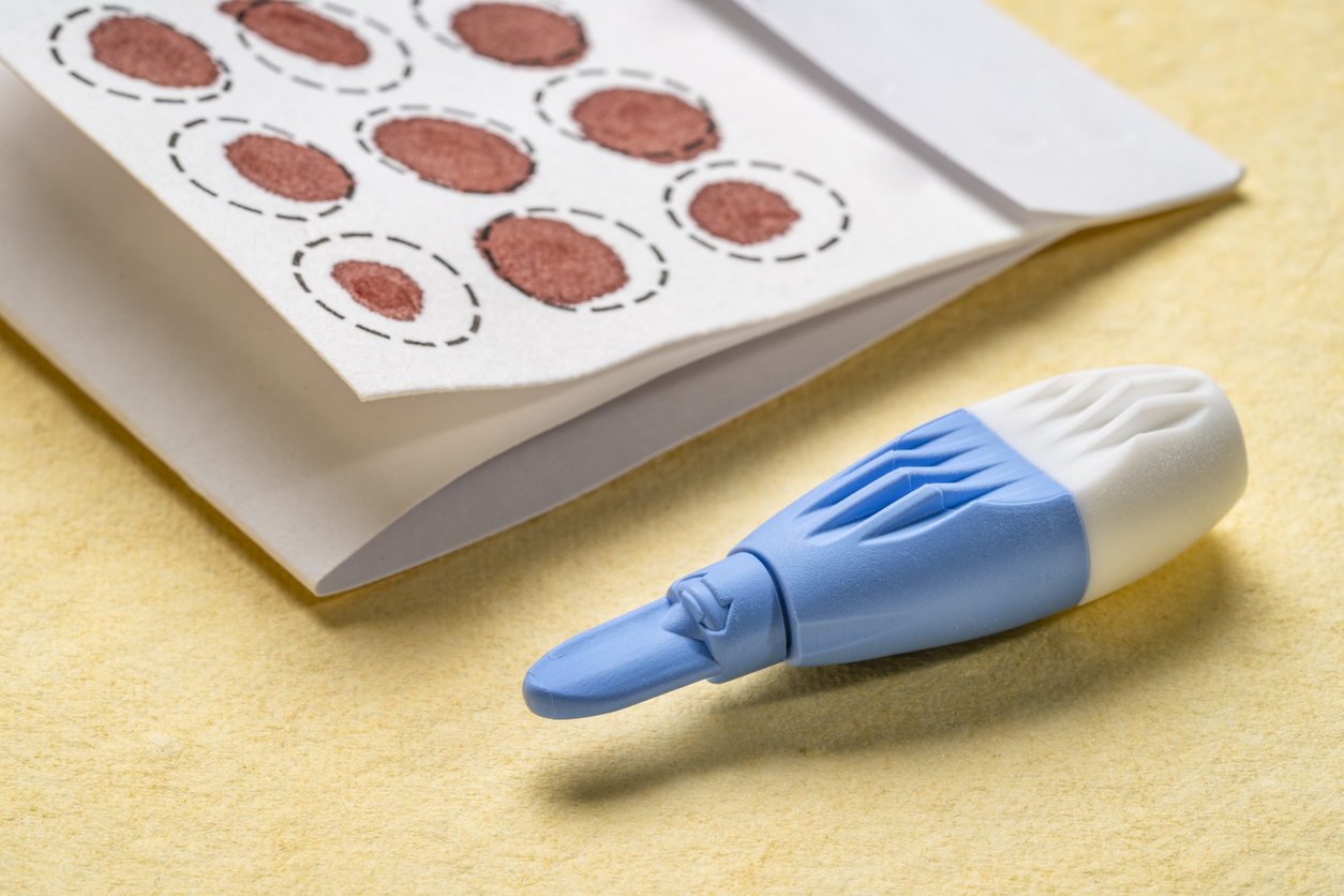 Getrocknete Bluttropfen von Fingerstichtest und Lanzette