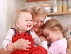 Großmutter hält Enkelsohn und Enkeltochter in den Armen