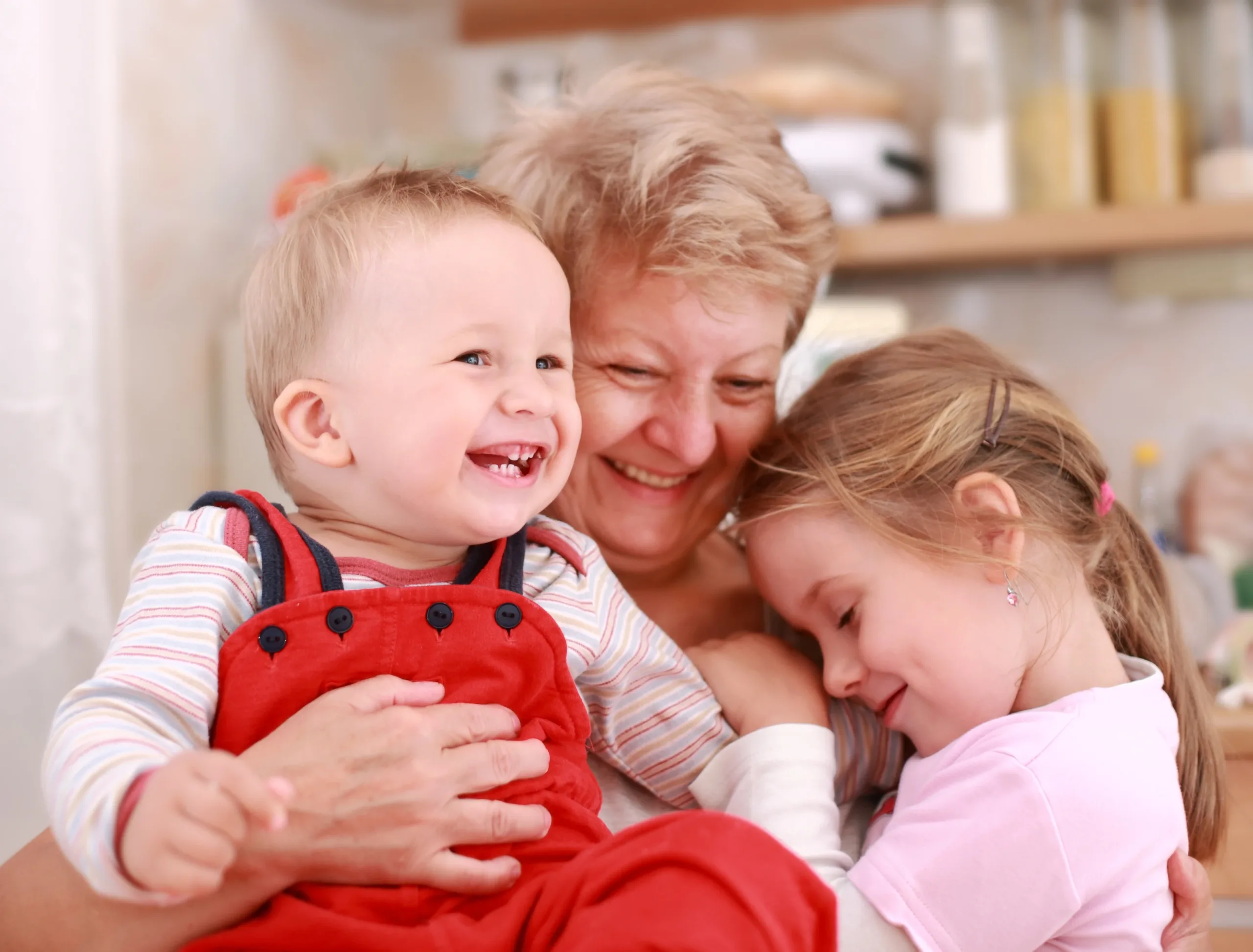 Großmutter hält Enkelsohn und Enkeltochter in den Armen