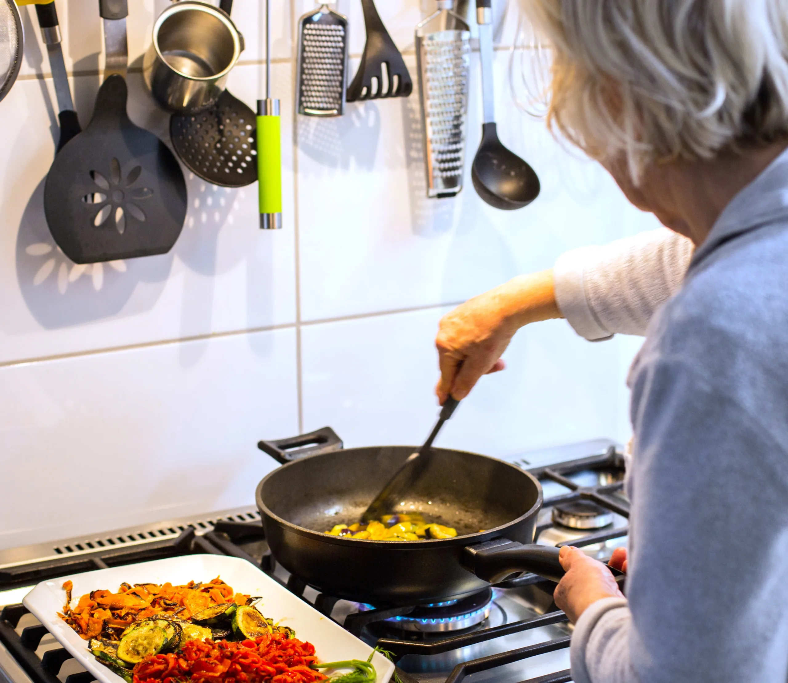 Frau bereitet eine warme Mahlzeit zu