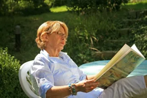 Ältere Frau liest im Garten